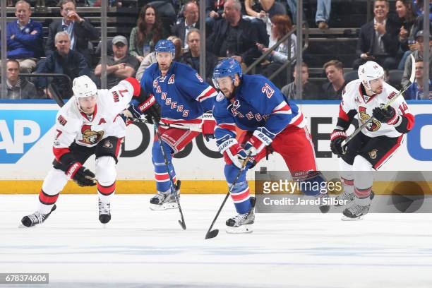 Derek Stepan of the New York Rangers skates against Kyle Turris and Alexandre Burrows of the Ottawa Senators in Game Three of the Eastern Conference...