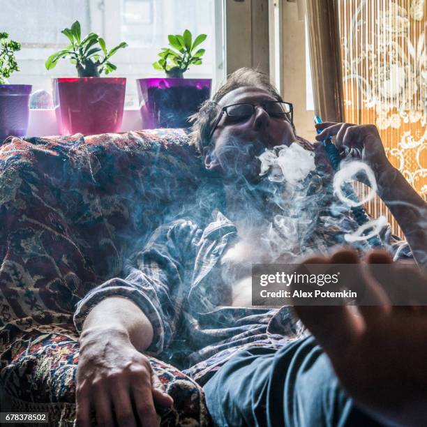 the young man smoking hookah - pipe smoking women stock pictures, royalty-free photos & images