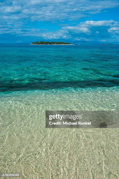 clear waters on beachcomber island with a little islet in the background, mamanucas islands, fiji, south pacific, pacific - beachcomber island stock pictures, royalty-free photos & images