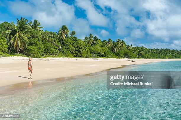 woman walking on a palm fringed white sand beach in haapai, haapai islands, tonga, south pacific, pacific - haapai islands stock pictures, royalty-free photos & images