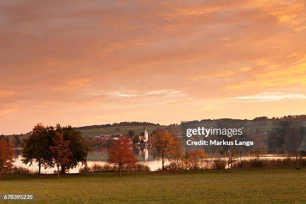 sunrise at riegsee lake with riegsee village, pfaffenwinkel, blaues land, upper bavaria, bavaria, germany, europe - lake riegsee stock pictures, royalty-free photos & images