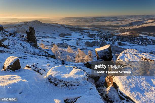 snow on millstone lit by sunrise, curbar and baslow edge with misty hills and wintry trees, peak district, derbyshire, england, united kingdom, europe - baslow stock pictures, royalty-free photos & images