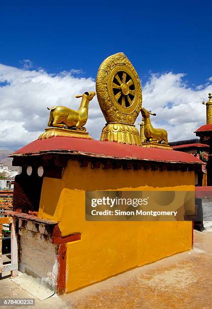 golden wheel of dharma and deer sculptures on the sacred jokhang temple roof, barkhor square, lhasa, tibet, china, asia  - dharmachakra stock pictures, royalty-free photos & images