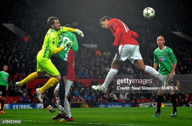 Cluj-Napoca goalkeeper Jorge Mario Felgueiras pucnhes clear from the head of Manchester United's Javier Hernandez