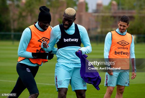 Cheikhou Kouyate of West Ham United playfully pushes Arthur Masuaku during training at Rush Green on May 4, 2017 in Romford, England.