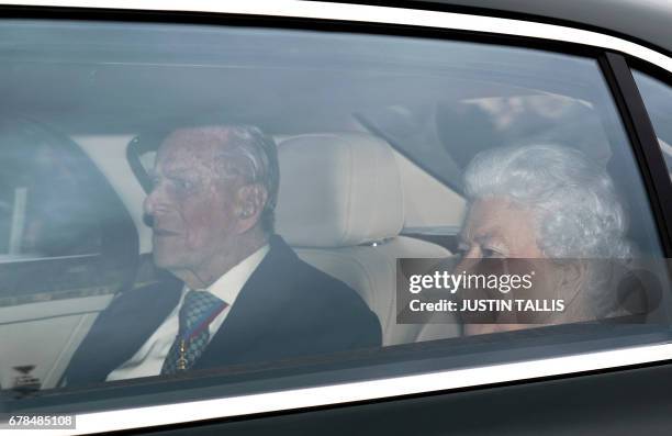 Britain's Queen Elizabeth II and Britain's Prince Philip, Duke of Edinburgh arrive back at Buckingham Palace in London on May 4 after attending a...