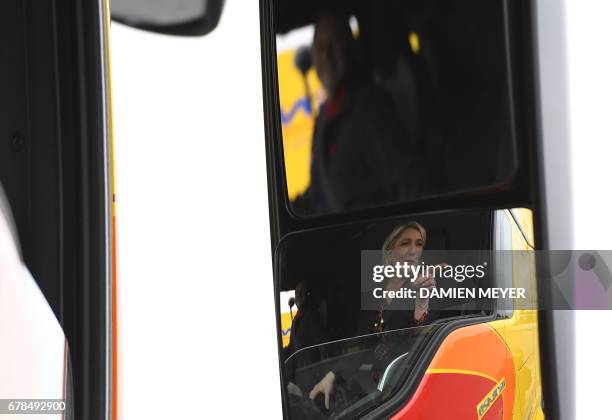 French presidential election candidate for the far-right Front National party, Marine Le Pen is reflected in the wing mirror of a lorry as she sits...