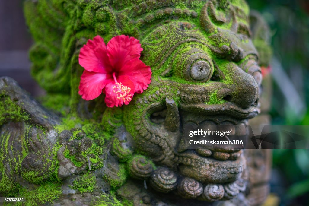 Sculpture of hindu god and goddess balinese style decoration by red flower form balinese offering in this morning