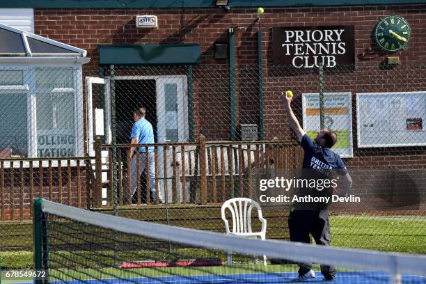 Man plays tennis at The Priory Tennis Club which is serving as a polling station in Stalybridge, Tameside, during the Manchester Mayoral election on...