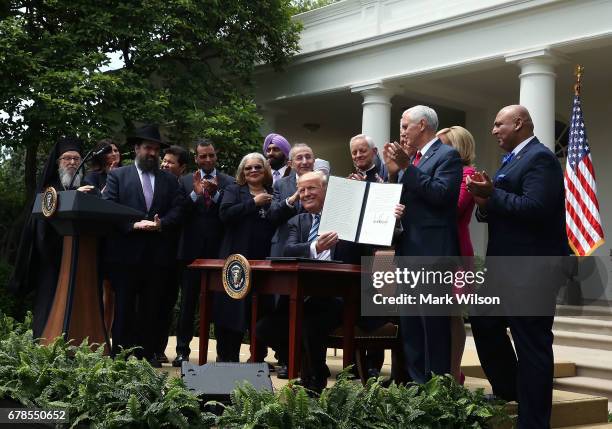 President Donald Trump is flanked by clergy members after signing an Executive Order on Promoting Free Speech and Religious Liberty, during a...