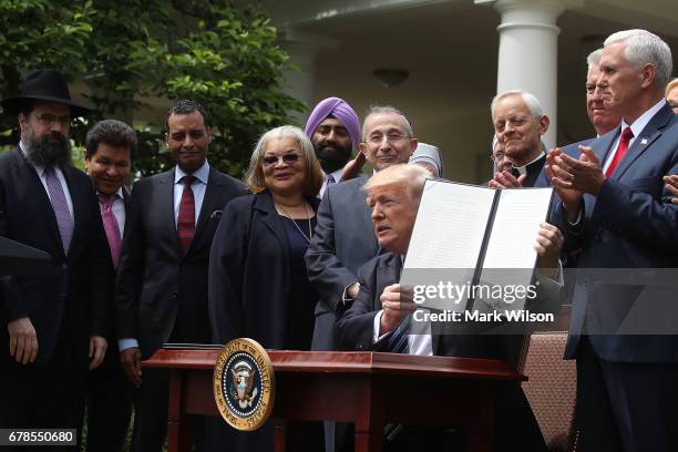 President Donald Trump is flanked by clergy members after signing an Executive Order on Promoting Free Speech and Religious Liberty, during a...