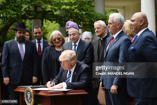 President Donald Trump signs an Executive Order on Promoting Free Speech and Religious Liberty in the Rose Garden of the White House on May 4, 2017...