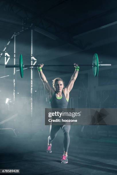 female athlete doing exercise with weights in gym - dumbbell stock pictures, royalty-free photos & images
