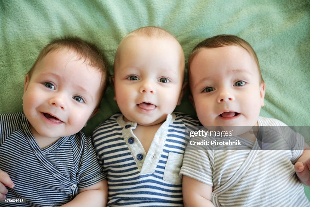 Retrato de trigêmeos recém-nascidos estão deitados na cama