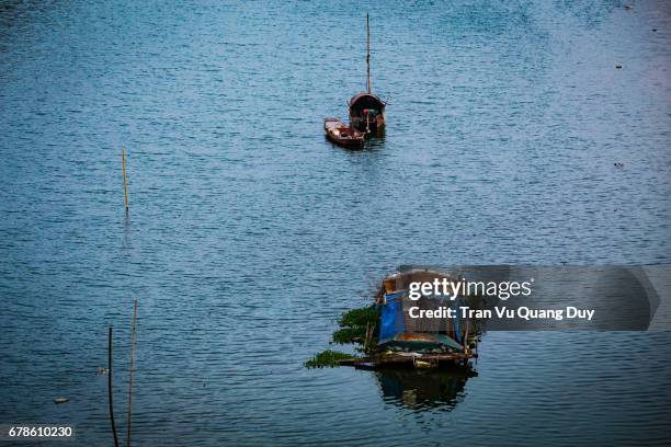 two boats on the red river, creating a quiet, romantic space. - cloud native stock pictures, royalty-free photos & images