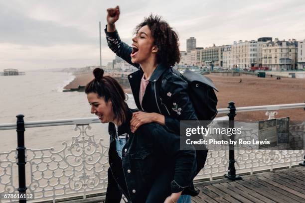 seaside couples - piggy back stockfoto's en -beelden