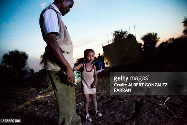 Yonan Samani , a Sudanese refugee and team leader of the Community Night Watchers in Doro refugee camp, finds and talks with a lost child on May 4,...