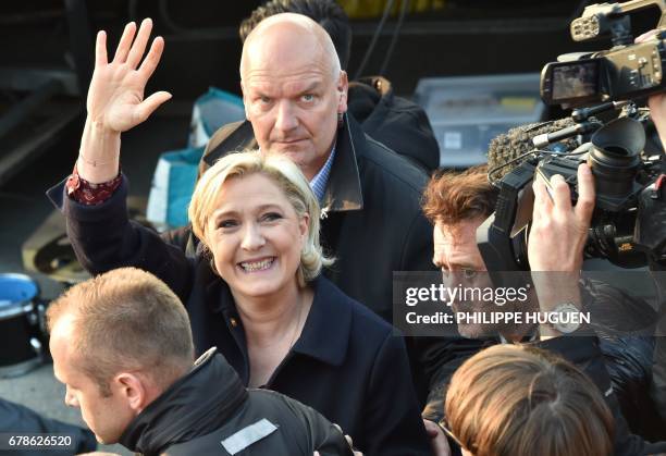 French presidential election candidate for the far-right Front National party, Marine Le Pen , followed by her bodyguard Thierry Legier , waves...