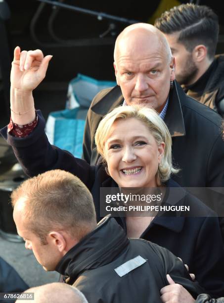 French presidential election candidate for the far-right Front National party, Marine Le Pen , followed by her bodyguard Thierry Legier , waves...