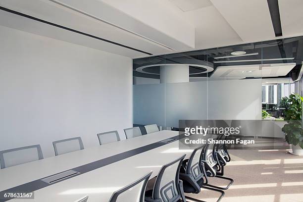 view of sunny conference room table and chairs - sala conferenze foto e immagini stock