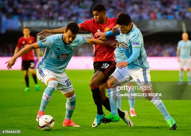 Manchester United's forward Marcus Rashford vies with Celta Vigo's Argentinian defender Gustavo Cabral and teammate Argentinian defender Facundo...
