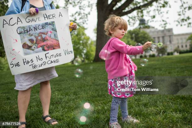 Charlie Wood of Charlottesville, Va., plays with bubbles during rally on the East Front lawn of the Capitol to oppose the House Republicans' bill to...