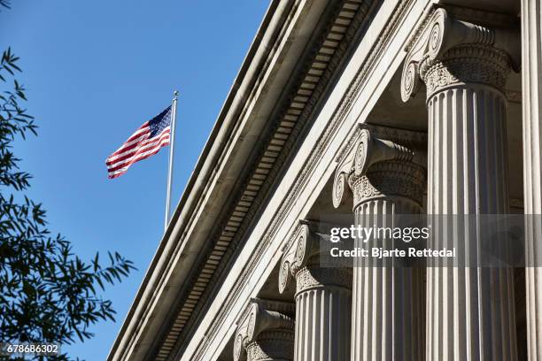 the american flag flying over the treasury department - us treasury money stock pictures, royalty-free photos & images