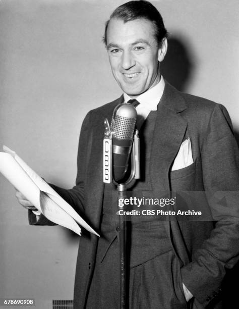 Gary Cooper poses for a photo at a microphone for The CBS Radio program, "Screen Guild Theater." This broadcast was a performance of an original...