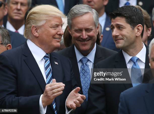 President Donald Trump , stands with House Speaker Paul Ryan and Freedom Caucus Chairman Mark Meadows , after Republicans passed legislation aimed at...