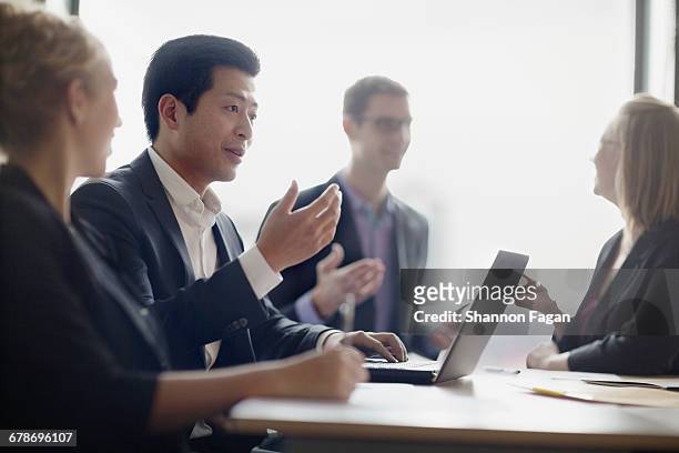 businessman talking with colleagues in meeting - business formal stock pictures, royalty-free photos & images