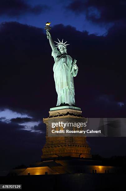 illuminated shot of statue of liberty at dusk. - statue of liberty shot stock pictures, royalty-free photos & images