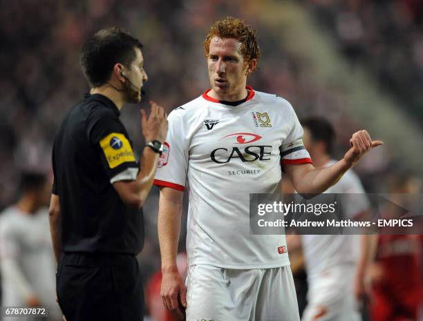 Milton Keynes Dons' Dean Lewington has a word with the referee's assistant