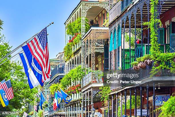 the wrought iron lace of a french quarter balcony - new orleans city stock-fotos und bilder