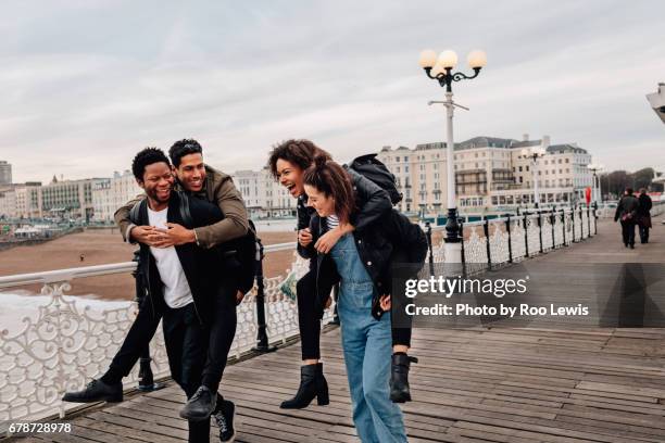 seaside couples - piggyback stock pictures, royalty-free photos & images