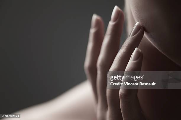 fingers on the cheek of a woman - frau gesicht beauty treatment stock-fotos und bilder