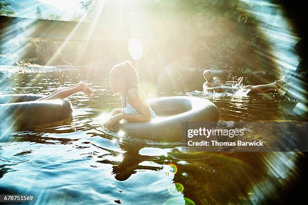 family floating on inner tubes on river - people swim river stockfoto's en -beelden