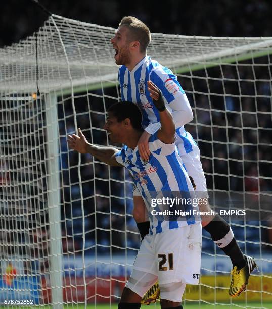 Huddersfield Town's Jermaine Beckford celebrates scoring the opening goal of the game against Millwall with Adam Clayton .