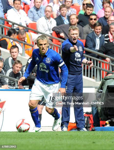 Everton's Phil Neville is watched by manager David Moyes on the touchline