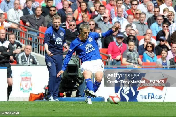 Everton's Phil Neville is watched by manager David Moyes on the touchline