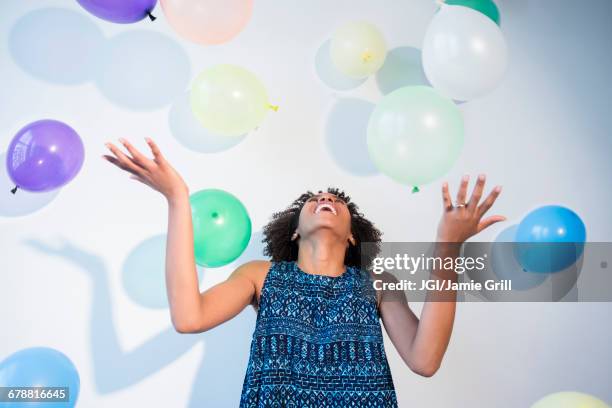 black woman watching falling balloons - grill party stockfoto's en -beelden