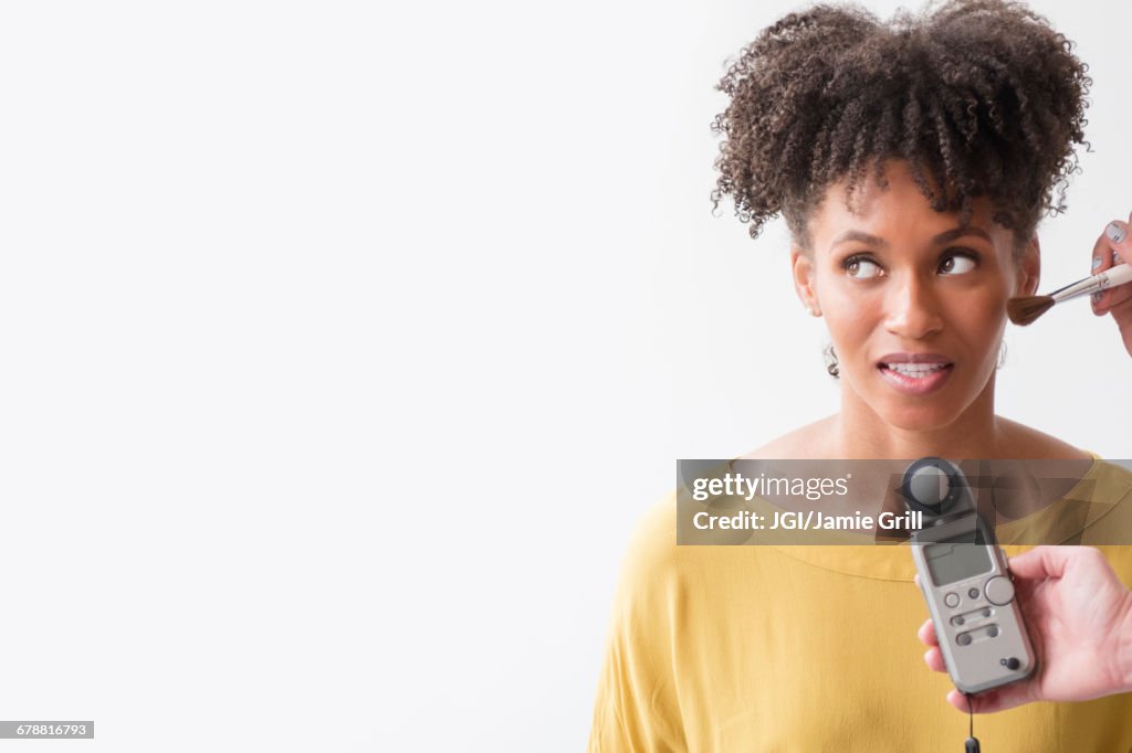 Makeup artist using makeup brush on woman