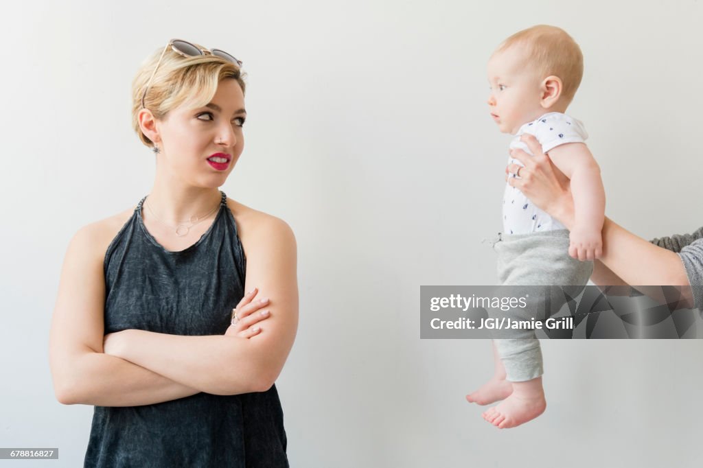 Caucasian woman disgusted at woman offering baby