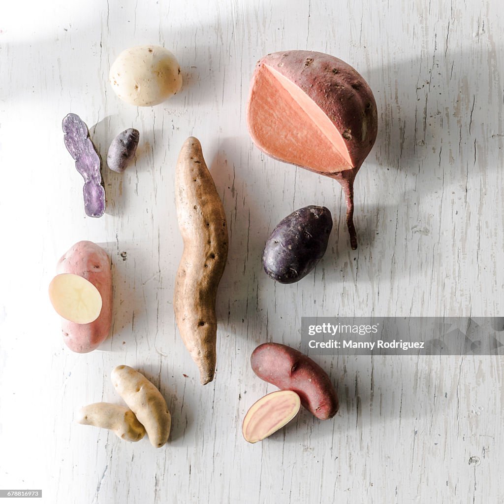 Variety of potatoes on white wooden table