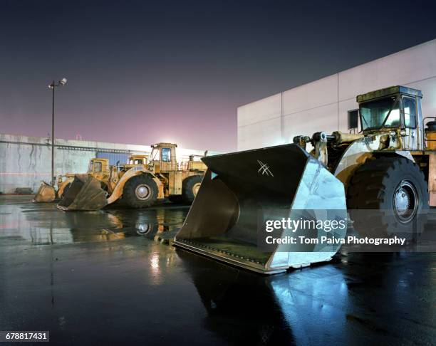 bulldozers in parking lot - vehículo de construcción fotografías e imágenes de stock