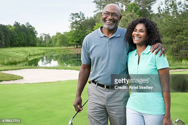 smiling black couple walking on golf course - golf accessories stock pictures, royalty-free photos & images