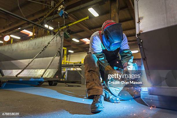 caucasian man welding metal in factory - work boot stock pictures, royalty-free photos & images