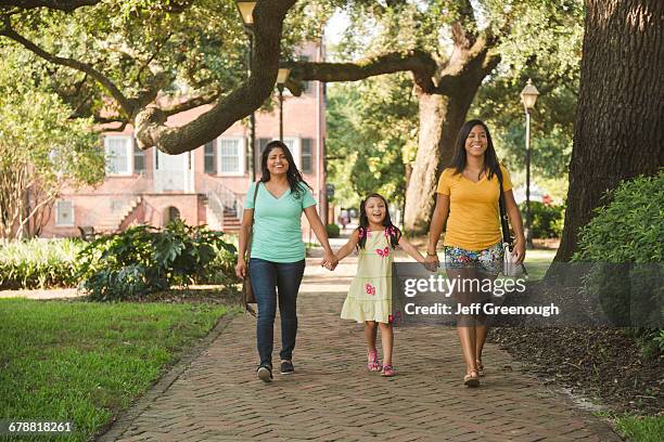 hispanic mother and daughters walking in park - savannah bildbanksfoton och bilder