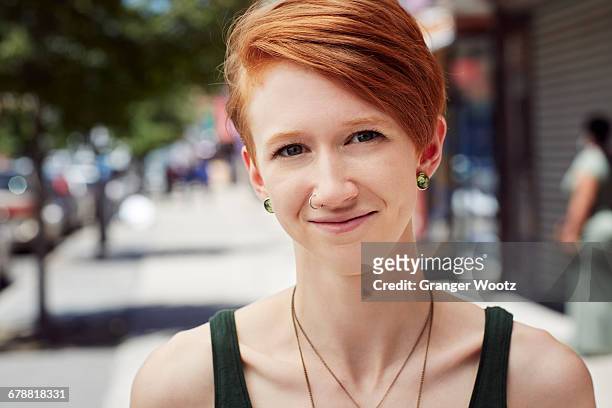 caucasian woman with nose ring smiling on city sidewalk - nose piercing - fotografias e filmes do acervo