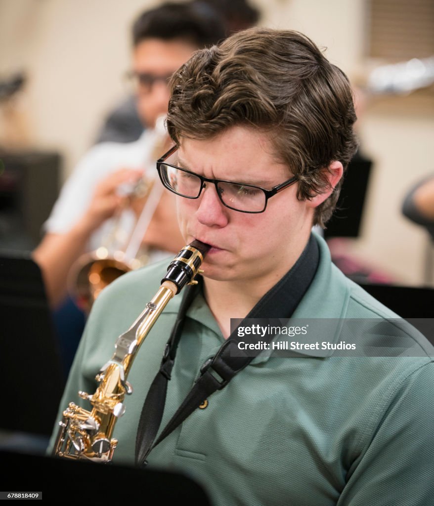 Boy playing saxophone in music class