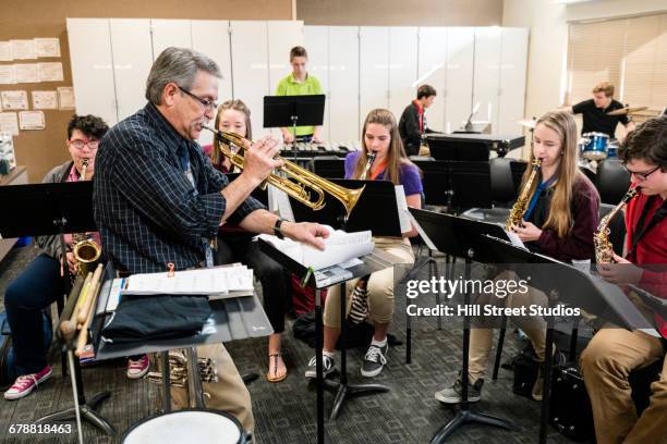 teacher playing trumpet in music class - woodwind instrument stock pictures, royalty-free photos & images